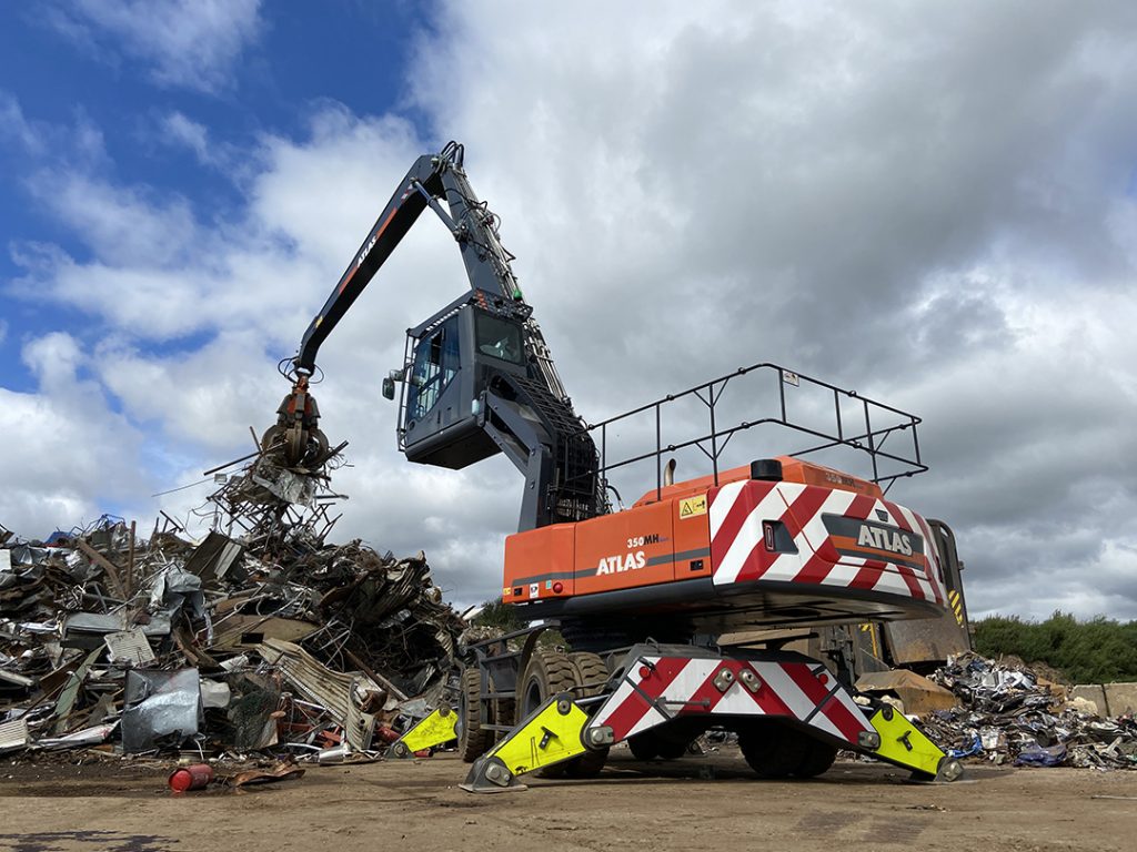 Atlas scrap handler moving scrap metal with grab