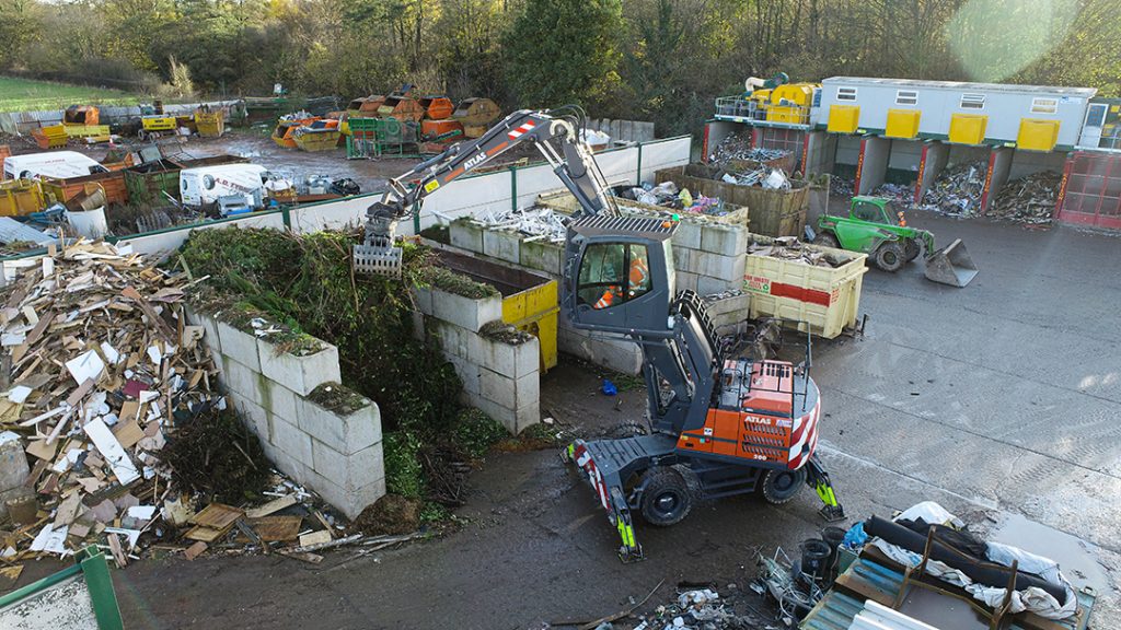 Atlas 200MH Material Handler Loading Skip Container at Banks Skip Hire Ltd